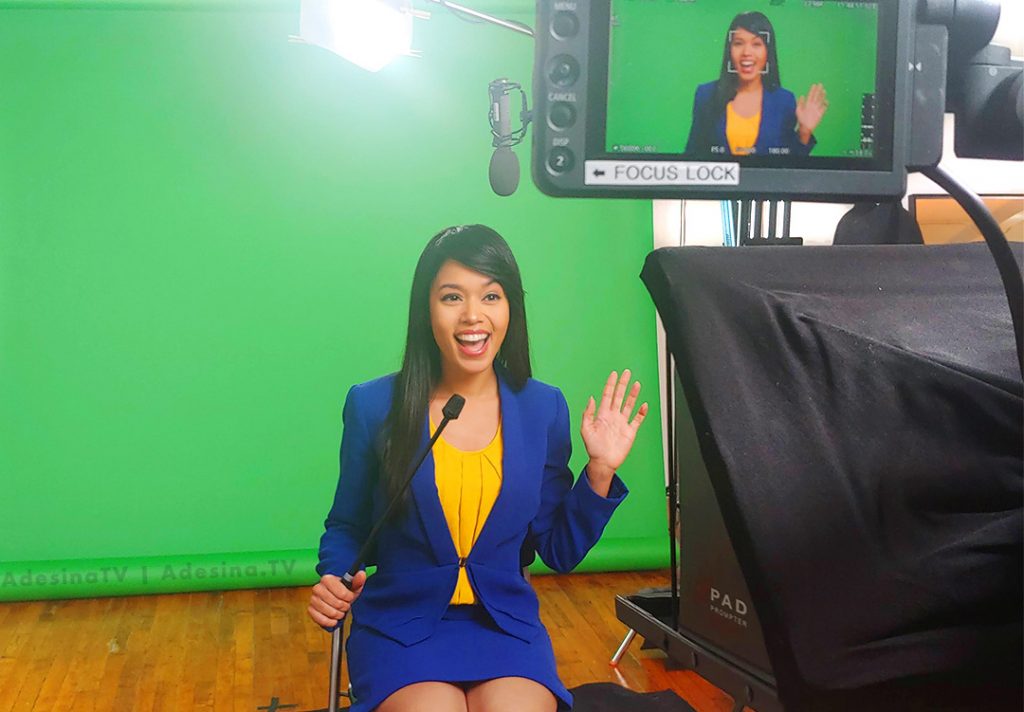 Adesina Sanchez in front of a greenscreen filming